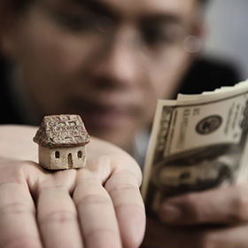 Hands Holding Money and a House